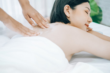 Fototapeta na wymiar Beautiful young woman lying down on beds massage and spa at asian spa massage and beauty salon center, spa concept, massage concept