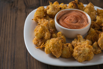 Cauliflower with sauce baked in batter with garlic.
