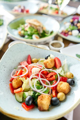 Traditional greek salad with fresh vegetables, feta cheese and olives. Variety of dishes on the table. Various snacks and antipasti on the table. Restaurant menu. Italian cuisine