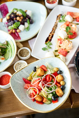 Traditional greek salad with fresh vegetables, feta cheese and olives. Variety of dishes on the table. Various snacks and antipasti on the table. Restaurant menu. Italian cuisine