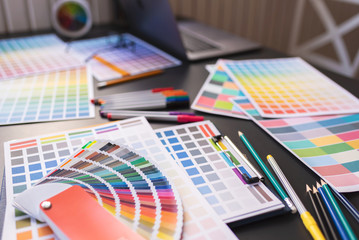 Color swatches of graphic designers putting on desk table.