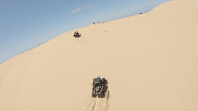 Chasing a pair of dune buggies as they summit a small hill in a wide orbit maneuver while maintaining focus