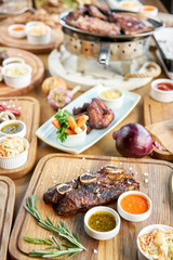 Beef meat cut according to the Argentine style, called asado. Barbecue restaurant menu. Many different food on the table. Dinner party or Banquet