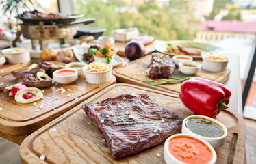 Grilled Skirt Steak. Barbecue restaurant menu. Many different food on the table. Dinner party or Banquet.