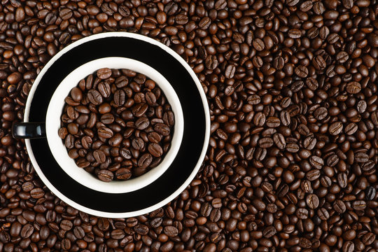 coffee background of coffee beens in red cup on roasted arabica coffee beans background