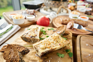 Beef bone marrow with chimichurri sauce and toasted bun. Barbecue restaurant menu. Many different food on the table. Dinner party or Banquet