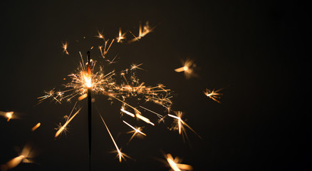 burning sparkler on dark background.