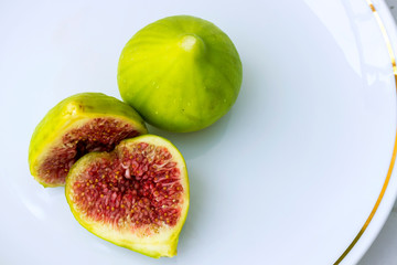 Fruits of figs on a plate close-up. Ripe sweet figs. View from above. Cut the figs. Sliced fresh fruit. Horizontal photo