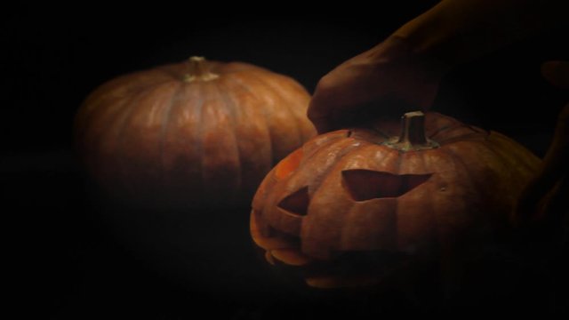 Halloween pumpkin head jack have the hands extended in and placed candles in the pumpkin.halloween and holidays concept.4K UHD video.