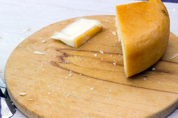 hard cheeses sliced on a wooden board on a dark rustic background