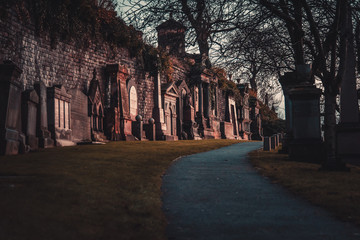 GLASGOW, SCOTLAND, DECEMBER 16, 2018: path to enter to the Glasgow Necropolis, surrounded quietly by lots of tombstones aside, shaping the way.
