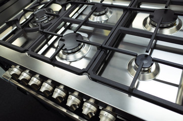 Close up of a brand new and clean stainless steel stove top/hop or a gas cooktop.