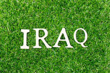 Wood letter in word Iraq on green grass background