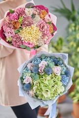 Two Beautiful bouquets of mixed flowers in womans hands. the work of the florist at a flower shop. Fresh cut flower.