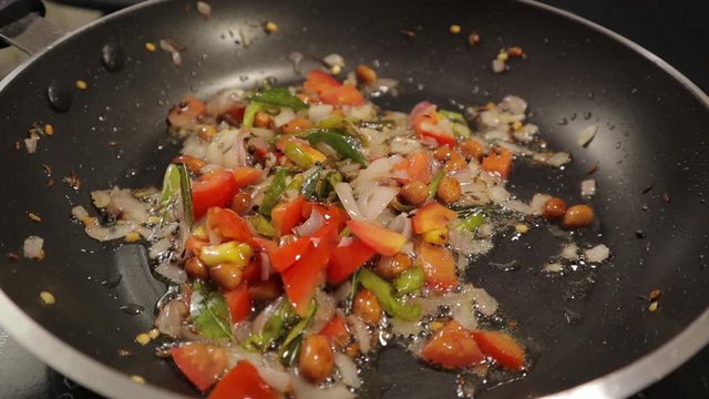 Adding salt to the frying veggies for preparing food in cooking the pan.