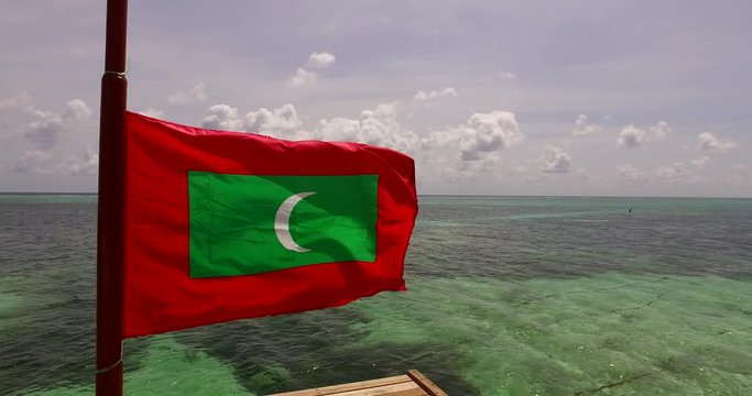 eye level view of maldives flag in pole near sea, still shot