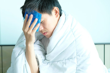 Sick man is flu, using a paper napkin and he have a runny nose. And he was covered in warm cloth.Health concept
