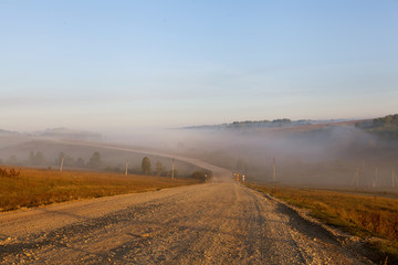 dirt road at dawn. Fog on the road
