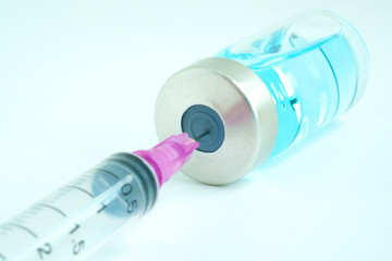 Fototapeta na wymiar doctor's hand holds a syringe and a blue vaccine bottle at the hospital. Health and medical concepts