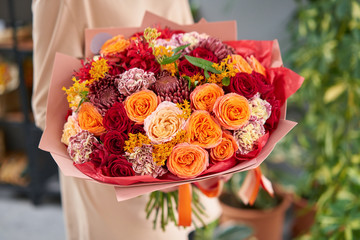 Beautiful bouquet of mixed flowers in womans hands. the work of the florist at a flower shop. Handsome fresh bouquet. Flowers delivery