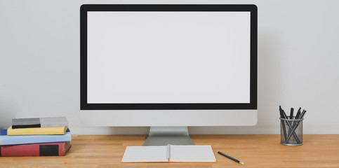Blank screen desktop computer in modern home-office room with office supplies