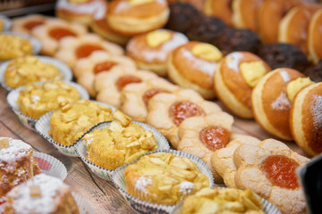 Donuts and rings. Hot pastries lie on the shelf in the cafe. Buns and chocolate muffins in the store.