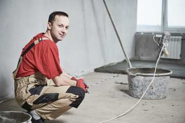 Floor cement work. Professional Plasterer portrait during smoothing floor surface