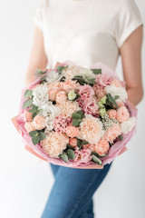 Beautiful bouquet of mixed flowers in womans hands. the work of the florist at a flower shop. Handsome fresh bouquet. Flowers delivery