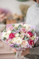 Beautiful bouquet of mixed flowers in womans hands. the work of the florist at a flower shop. Handsome fresh bouquet. Flowers delivery