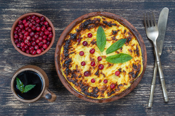 Sweet cottage cheese casserole with raisins and semolina on wooden table. Ceramic bowl with baked cottage cheese casserole , closeup, top view