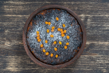 Sweet casserole with a burnt crust on wooden table. Ceramic bowl with baked cottage cheese casserole , close up
