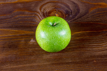 fresh green apple close up on a brown wooden backgroung ,colorful tasty fruit macro