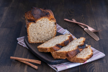 Homemade banana bread with cinnamon on a wooden background, close up