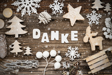 Letters Building The Word Danke Means Thank You. Wooden Christmas Decoration Like Tree, Sled And Star. Brown Wooden Background With Snowflakes