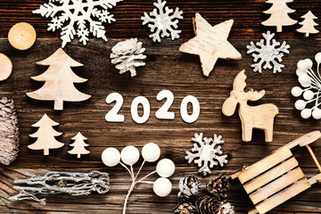 White Letters Building The Word 2020. Wooden Christmas Decoration Like Seld And Tree And Star. Brown Wooden Background