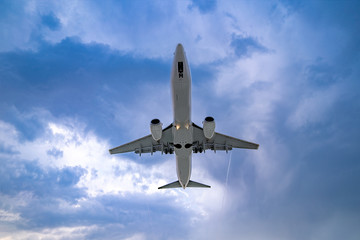 Obraz premium Flying passenger airplane in the cloudy sky