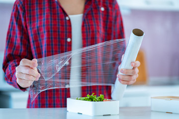 Using food polyethylene plastic film for food storage in fridge at home