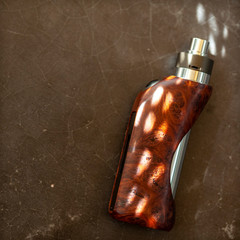 high end natural stabilized wood regulated box mods with rebuildable dripping atomizer on dark grey...