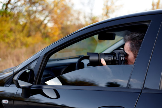 Young man with a dslr camera in a car.