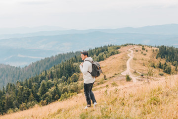 Naklejka na ściany i meble man with backpack hiking by autumn mountains