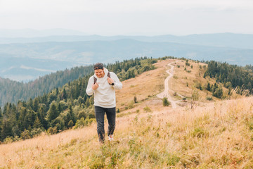 Fototapeta na wymiar man with backpack hiking by autumn mountains