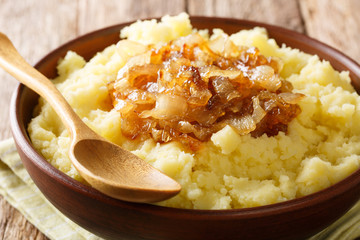 Simple food mashed potatoes with caramelized onions close-up on a plate. horizontal