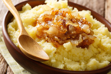 Vegetarian rustic food mashed potatoes with caramelized onions close-up on a plate on the table. horizontal