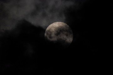 Naklejka na ściany i meble full moon scary night, view of full moon rising in dark sky around with dark clouds moving in rainy sky background.