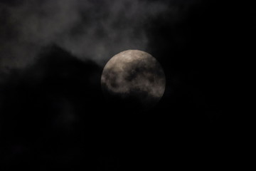 full moon scary night, view of full moon rising in dark sky around with dark clouds moving in rainy sky background.