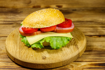 Fresh delicious homemade cheeseburger on wooden table