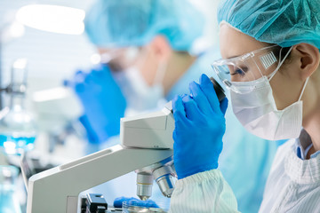asian scientist use microscope
