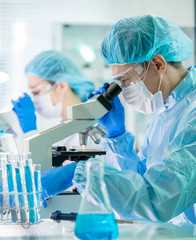 asian scientist use microscope