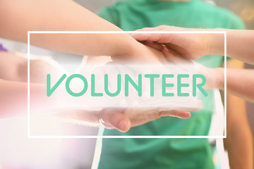 Group of volunteers joining hands together, closeup