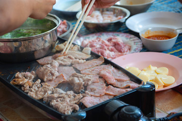 Grilled pork on the stove is being cooked. Flavored with seasonings Cubed with chopsticks Delicious Asian food